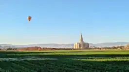 The Red Cliffs Utah Temple, with an air balloon in the distance