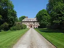 A driveway leading through a park to a mansion