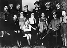 13.8.1943, The political Nazi leader Reichel (from Erdmannsdorf in Saxony) with his wife and twelve children all dressed in Nazi Party or military uniforms. The mother is decorated with the Cross of Honor of the German Mother.Five sons are with the German Wehrmacht; the sixth is with the Reich Labor Service. The smaller children are all members of Nazi youth organizations. The youngest girls have Wolfsangel symbols on their dresses; a sign for members in NS-Frauenschaft's Deutsche Kinderschar for children aged between 6 and 10.Photo: Bundesarchiv (German Federal Archives)