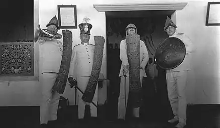 Prof.Rodenwalt and Dr.de Wolf with traditional arms posing in front of the house of the Sultan of Ternate.