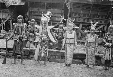 Men in military clothing and two women in ceremonial clothing in Bawodobara