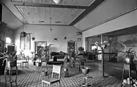 Interior upstairs foyer featuring a Wunderlich ceiling, blackwood staircase, carpets, lamps, lighting fixtures, paintings, urns and plants