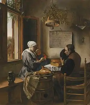 A man, woman, and infant at a table by a window