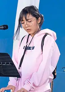 photograph of lilypichu playing the piano at a twitch concert