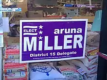 An image of a campaign sign for Aruna Miller for Delegate in the window of a local grocery store
