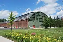 The rear of the armory, with a green wall and many windows in the upper section