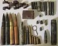 Artifacts found at the former Sahuarita Air Force Range, including a 20 mm anti-aircraft gun casing and belt link, M2 bullets and casings, M1919 bullets, casings, and a machine gun belt link, M1 Garand bullets, casings, and a stripper clip, M1 Carbine bullets and casings, M1911 bullets and casings, a .22 bullet and casing, some unidentified casings, and an Mk 2 grenade pin.