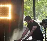 A color photograph of The Haxan Cloak, who is performing live at a 2014 music festival.