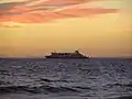 The Spirit of Tasmania sailing through Port Phillip in dusk seen from Elwood Beach