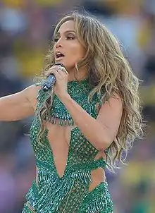 Jennifer Lopez singing on stage in a green outfit
