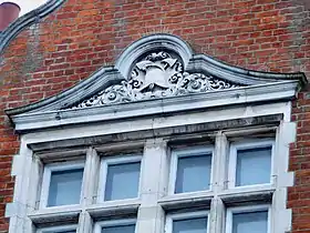 Window pediment with carved fire helmet and axe